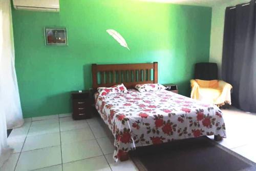 Dormitorio verde con cama y pared verde en Aconchego natureza: Massarandupió Beach, 5k para a Praia, en Massarandupio
