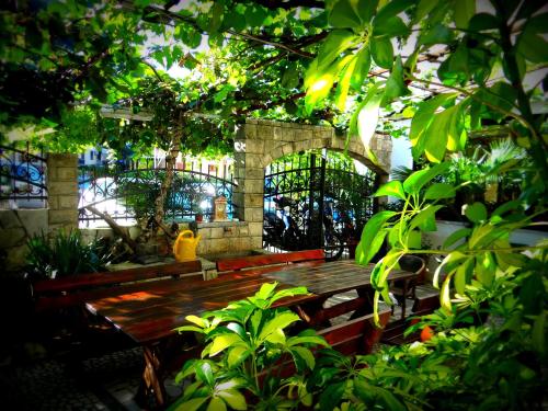 a wooden picnic table in a garden with trees at Saki Apartments in Budva