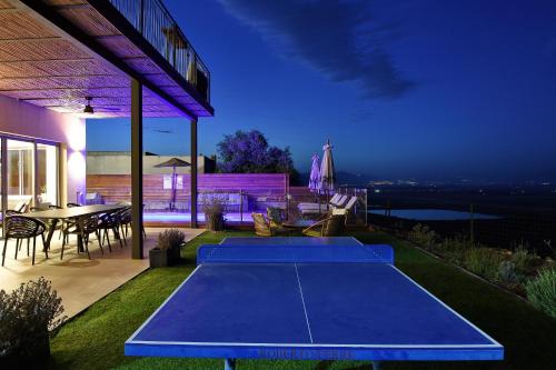 a blue ping pong table on a patio at night at THE ALTA GALILEA - 2BRM WITH POOl/Amazing view/Gakuzi in Mishmār Hāyardin