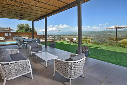 a patio with chairs and a table with a view at THE ALTA GALILEA - 2BRM WITH POOl/Amazing view/Gakuzi in Mishmār Hāyardin