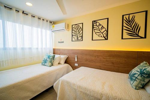 um quarto com 2 camas e uma janela em Laguito Houstel Loft Medium em Cartagena das Índias