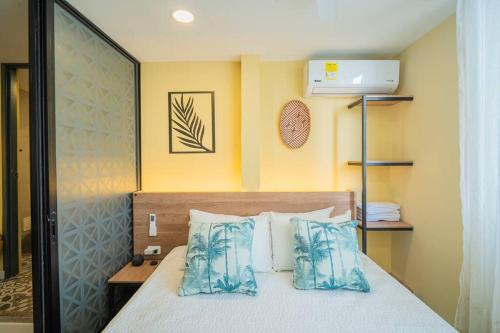 um quarto com uma cama com almofadas azuis em Laguito Houstel Loft Medium em Cartagena das Índias