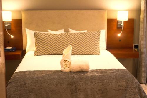 a hotel room with a bed with a towel on it at Hotel Destiny in Ongwediva