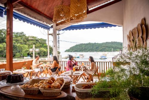Samburá Paraty في باراتي: مجموعة من الناس يجلسون على الطاولات في الفناء