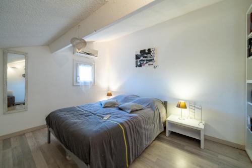 1 dormitorio con 1 cama en una habitación blanca en Charmante petite maison au calme, en Villeneuve-Loubet