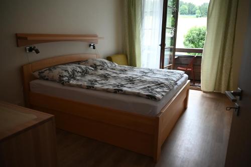 a bedroom with a bed and a window with a view at Apartmán PERLA 28, Říčky in Říčky