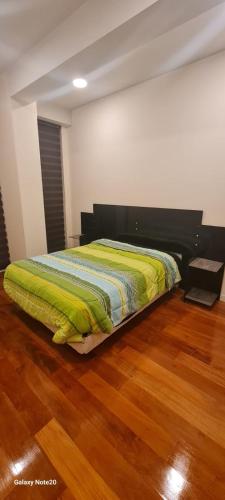 Łóżko w pokoju z drewnianą podłogą w obiekcie departamento de 2 dormitorios w mieście La Paz