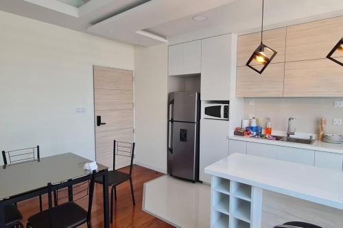Il comprend une cuisine équipée d'un réfrigérateur et d'une table avec des chaises. dans l'établissement departamento de 2 dormitorios, à La Paz