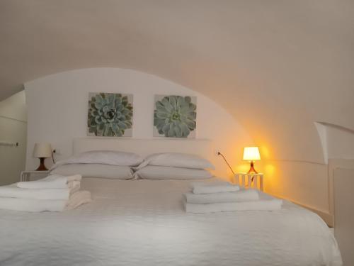 Dormitorio blanco con cama blanca y almohadas en Giulietta Central Loft, en San Remo