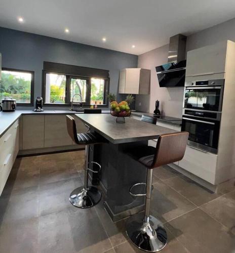 a large kitchen with a island in the middle at Villa Fleur de Coco - 8p. - piscine privée - haut standing in Saint-Pierre