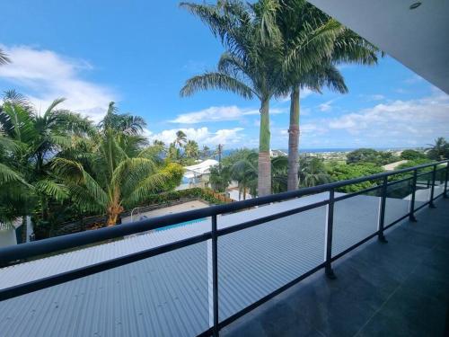 a balcony with palm trees and a white fence at Villa Fleur de Coco - 8p. - piscine privée - haut standing in Saint-Pierre