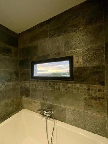 a bathroom with a bath tub with a window at Villa Fleur de Coco - 8p. - piscine privée - haut standing in Saint-Pierre