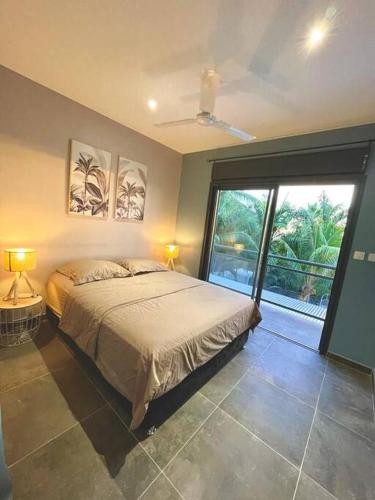 a bedroom with a bed and a large sliding glass door at Villa Fleur de Coco - 8p. - piscine privée - haut standing in Saint-Pierre