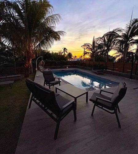 a pool with three chairs and a table and a tablektop at Villa Fleur de Coco - 8p. - piscine privée - haut standing in Saint-Pierre
