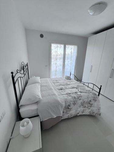 una camera bianca con un grande letto e una finestra di Casa vacanze Sofy & Marty a Cattolica
