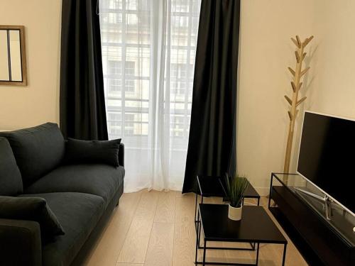 Le Bijou du Martroi في أورليان: غرفة معيشة مع أريكة ونافذة كبيرة