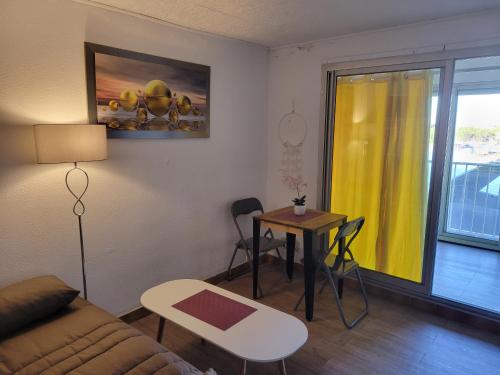 een woonkamer met een bank en een tafel bij residence du mail in Cap d'Agde