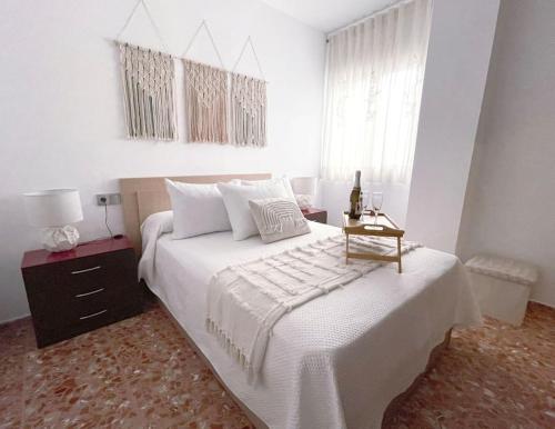 a bedroom with a large white bed with a night stand at Mi rincón favorito in Cogollos De La Vega