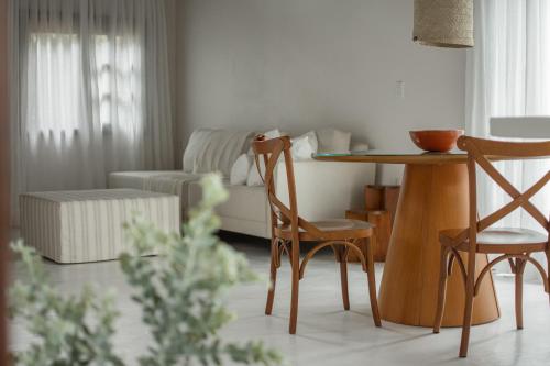 a living room with a table and chairs at Aurora e Vale in Praia do Rosa