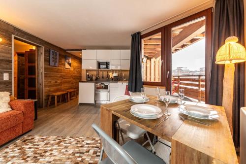 une cuisine et un salon avec une table et des chaises dans l'établissement IMMODREAMS - Le Cerf, à Morzine