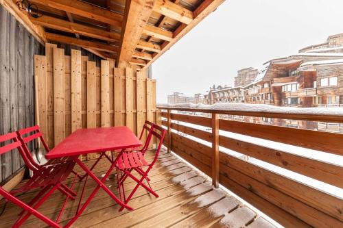 - deux chaises rouges et une table rouge sur un balcon dans l'établissement IMMODREAMS - Le Cerf, à Morzine