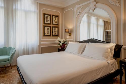 ヴェネツィアにあるホテル サント ステファノのベッドルーム(大型ベッド1台、青い椅子付)