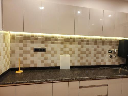 a kitchen with a sink and a tiled wall at MYKA SD ZANITA HEIGHTS in Vasco Da Gama