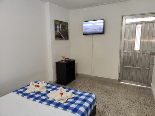 a bedroom with a blue and white bed with towels on it at Absolute Hotel & Hostel Boutique in Medellín