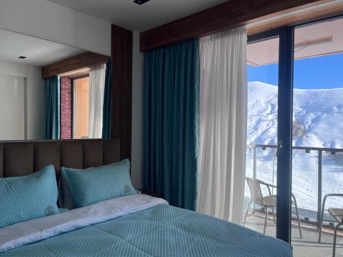 a bedroom with a bed and a view of a mountain at Luxury apartment with specticular views in Gudauri
