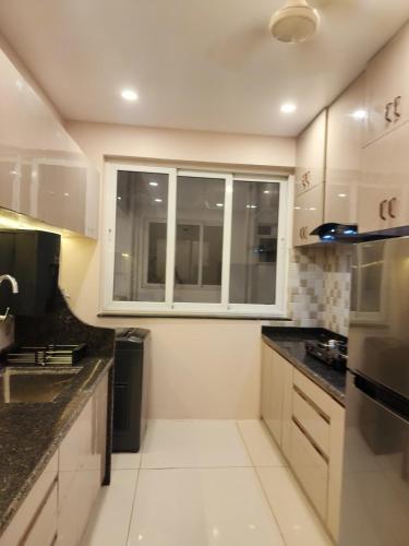 a kitchen with white cabinets and a window at MYKA SD ZANITA HEIGHTS in Vasco Da Gama
