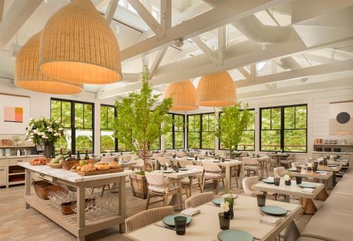 un restaurante con mesas, sillas y ventanas grandes en MacArthur Place Inn & Spa, en Sonoma