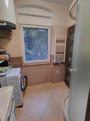 a kitchen with a washing machine and a window at Villa Pirken Hammer in Pirkenhammer