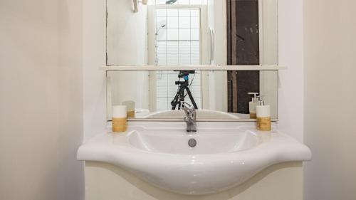 - un lavabo blanc avec miroir et une caméra dans l'établissement Smart Confort 8 - Studio confort et stylé, à Troyes