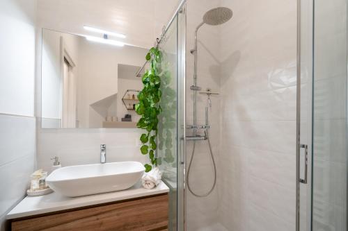uma casa de banho branca com um lavatório e um chuveiro em [Porta Nuova - Alpitour] Free Parking & Netflix em Turim