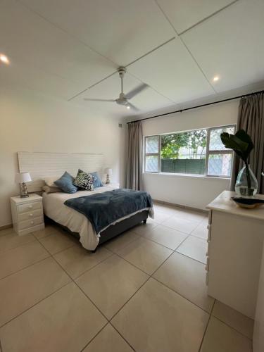 1 dormitorio con cama y ventana grande en Pompano Corner, en Richards Bay