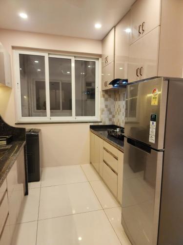 a kitchen with white cabinets and a stainless steel refrigerator at MYKA SD ZANITA HEIGHTS in Vasco Da Gama