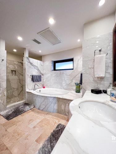 a large bathroom with a tub and a sink at Casa Marvela at Playa de La Paz - 4br Beach front Villa, Access to Beach Club in La Paz