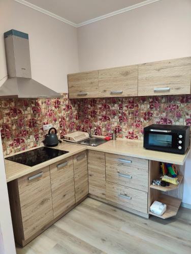 a kitchen with wooden cabinets and a microwave at Villa Pirken Hammer in Pirkenhammer