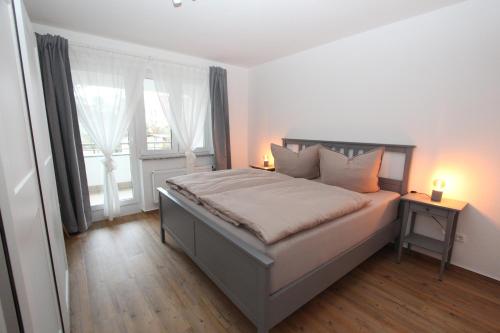 1 dormitorio con 1 cama con 2 lámparas y una ventana en Ferienwohnung Bad Saarow, Seestr. 2, en Bad Saarow