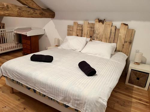 Lesterps的住宿－Gîte à l'ombre des Magnolias，一间卧室配有一张大床,上面有两顶帽子