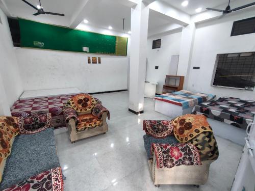 ein Zimmer mit Sofas und Stühlen in einem Zimmer in der Unterkunft Nagpur Tuljai Villa Homestay in Khāpri