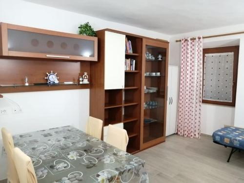a dining room with a table and a book shelf at SWEET LIANA un tuffo nel cuore del paese in Porto Santo Stefano