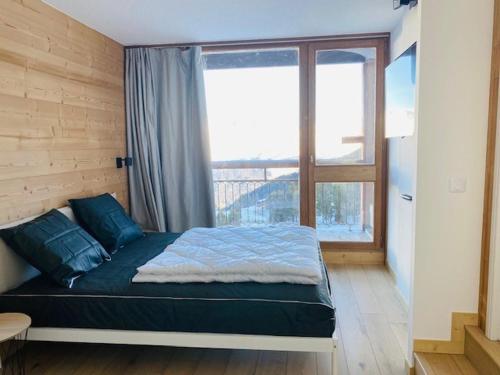 une chambre avec un lit et une grande fenêtre dans l'établissement Appartement 3 pièces rénové, face Mont-Blanc, ski aux pieds, balcon, proche centre station - FR-1-346-529, à Arc 2000