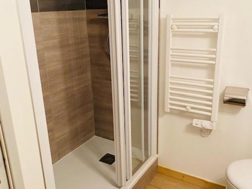 La salle de bains est pourvue d'une douche en verre et de toilettes. dans l'établissement Appartement 3 pièces rénové, face Mont-Blanc, ski aux pieds, balcon, proche centre station - FR-1-346-529, à Arc 2000