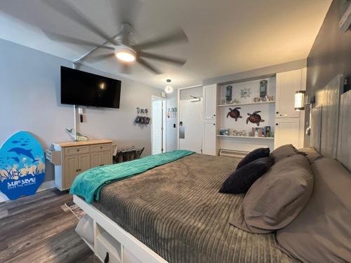 a bedroom with a large bed with a ceiling fan at Ocean Pool King Bed in Daytona Beach