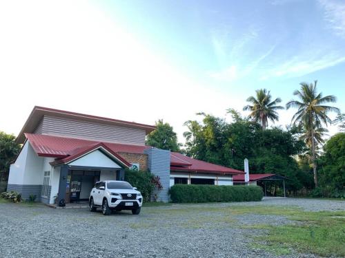 a white truck parked in front of a building at Batis ni Juan Leisureland in Dipaculao