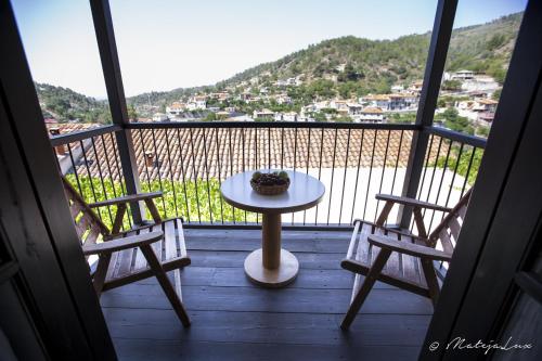 a table and two chairs on a balcony with a view at Ambelikos Traditional Agrohotel in Potamitissa