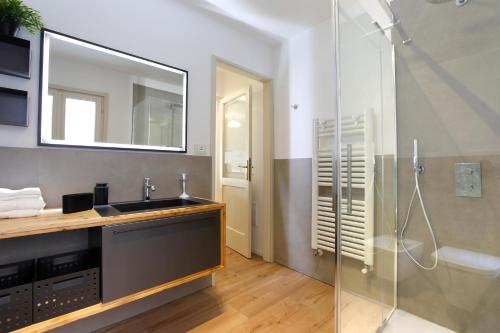 a bathroom with a sink and a shower with a mirror at 25 Lazzaro Bonamigo in Bassano del Grappa
