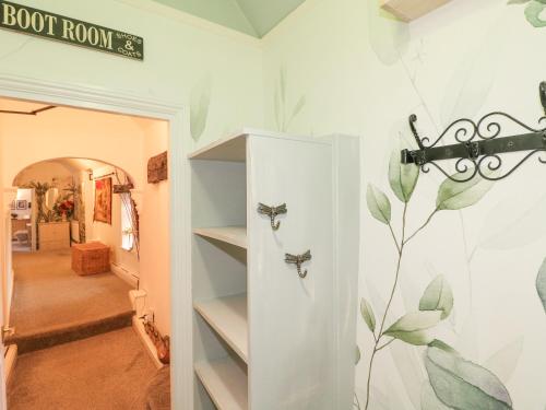 a room with a book shelf with a painting on the wall at Flat 2, The Maltings in Oakham