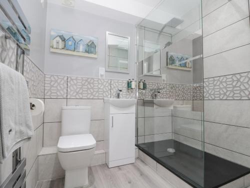 ReightonにあるWhite Rose Apartmentのトイレとガラスのシャワー付きのバスルーム